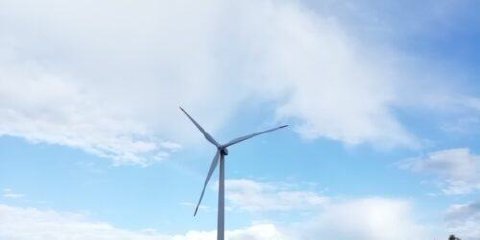 A single wind turbine against a cloudy sky